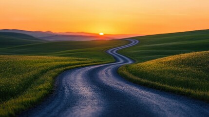 Fototapeta premium Winding road cutting through lush green fields leading towards a breathtaking sunrise that illuminates the horizon