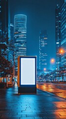Illuminated billboard stands out against the backdrop of towering skyscrapers in a modern cityscape at night, creating a striking contrast of light and architecture.