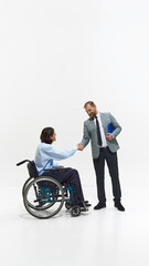 Man, employee in wheelchair shaking hands with man in suit. Inclusivity and respect in business environment. Concept of business, dei, equality, support
