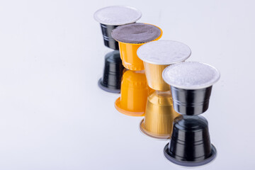 Different colored coffee capsules creatively placed on a mirror with a white background