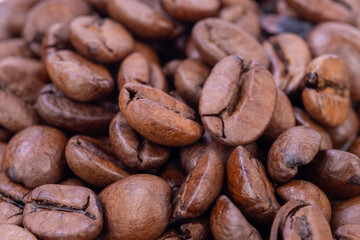 Macro shot of coffee beans placed on a mirror against a white background, showcasing their rich brown hues and intricate surface details