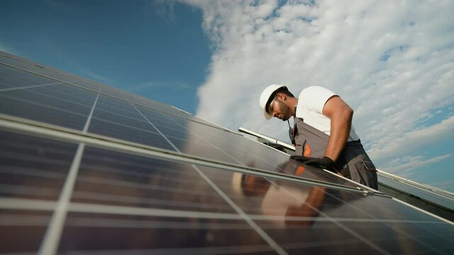 Indian technician performing solar panel maintenance outdoors
