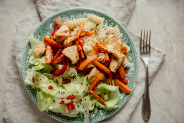 Plate with healthy food: pasta, salad, meat, stewed vegetables, seeds. A plate of balanced nutrition.