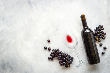 Red wine in the bottle with bunch of grapes and glass, top view