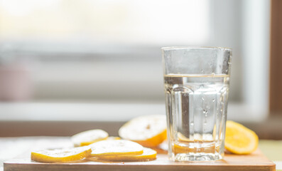 Close up of a lemon slices and a glass of water. Healthy food or drink concept.