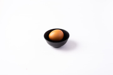Simple Egg in Black Bowl on White Background