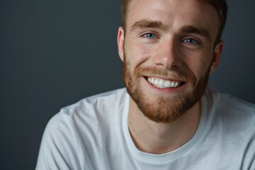 Fototapeta premium Smiling young man in white shirt showing healthy teeth.