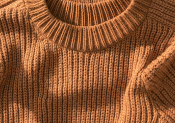 Close-up of a brown knitted wool fabric, showcasing its texture and the intricate details of the knitting