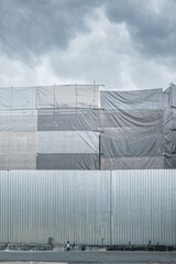 Construction site building with scaffold and closed fence for safety