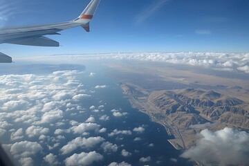 Obraz premium Aerial View of Coastal Landscape with Clouds and Mountains