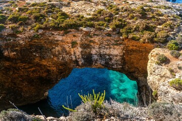 cave in the sea in Comino Island in Malta with crystal water cliff 