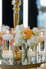 Elegant gold candelabras with lit candles and floral arrangements on a decorative table