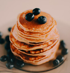 Delicious fresh pancakes for breakfast, decorated with ripe blueberries, make for a healthy breakfast. A delightful dessert.