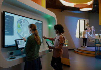 Diverse students engaging in interactive learning, using a large touchscreen whiteboard and digital tablets in a technologically advanced classroom