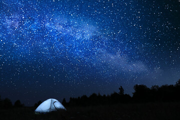 Modern camping tent in wilderness at night, slow shutter speed effect