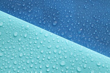 Water drops on color background, above view