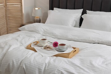 Breakfast tray on bed with beautiful linens indoors