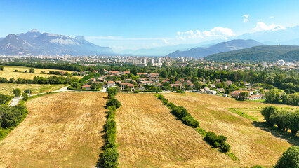 view of Grenoble and its mountains from a field in summer