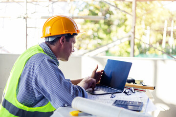 Caucasian Male architect engineer construction worker using computer laptop working on blueprint design plan using pencil tool analyzing design innovation building landscape housing architecture.