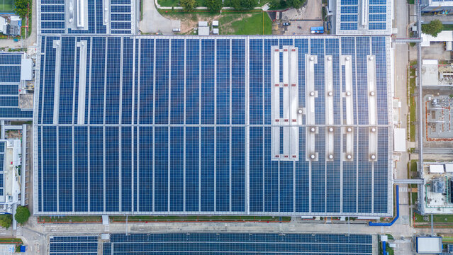 Top view Solar Cell on Warehouse Factory. Solor photo voltaic panels system power or Solar Cell on industrial building roof for producing green ecological electricity. Production of renewable energy.