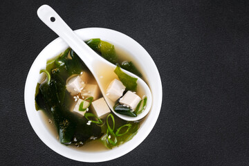 Seaweed soup with tofu on wooden board.