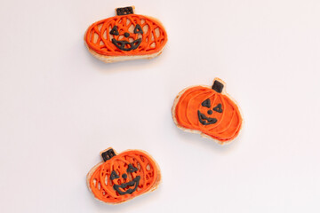 Halloween gingerbread cookies pumpkin shape on white background. Bright homemade cookies for Halloween party