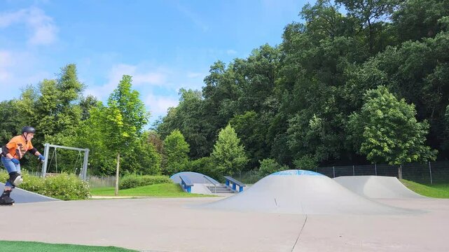 Ein Mann, der mit Inlineskates auf einer Halfpipe in einem Skatepark f&auml;hrt. 