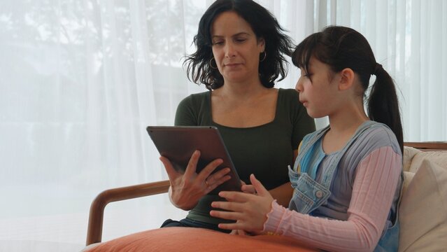 Granddaughter guide grandmother how to use touch screen control tablet. Senior adapt to technology activity communicate new generation kid cross generation gap strengthen family bond. Divergence.