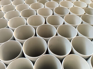 close up of a bunch of white pvc pipes. round plastic pipe