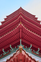A stunning view of a traditional pagoda roof, captured from below. The vibrant red tiles and...