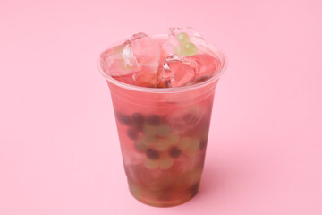Tasty bubble tea in plastic cup on pink background