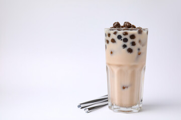 Tasty milk bubble tea in glass and straws on white background, space for text