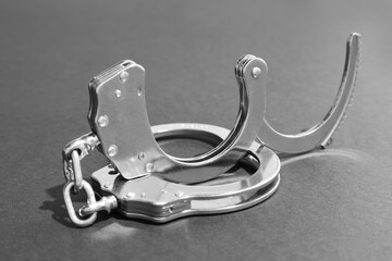 Classic chain handcuffs on grey background, closeup
