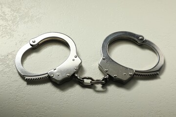Classic chain handcuffs on white table, closeup