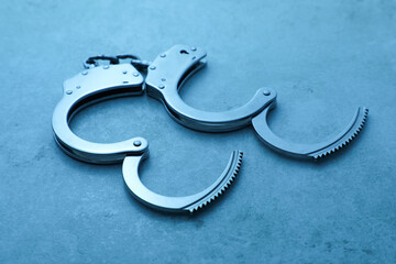 Classic chain handcuffs on table, closeup. Color toned