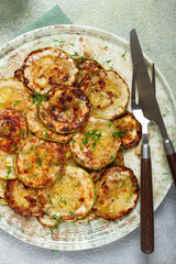 fried zucchini, cut into rings, with garlic and herbs, on a plate, top view, homemade, no people,