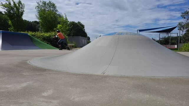 Ein Mann, der mit Inlineskates auf einer Halfpipe in einem Skatepark f&auml;hrt. 