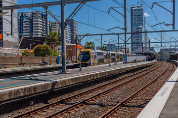 Commuter Passenger Train moving fast moving through a Burwood Train Station in Sydney NSW Australia