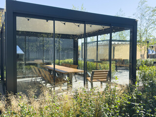 A spacious barbecue area with a canopy made from natural materials, enclosed. A patio with a table...