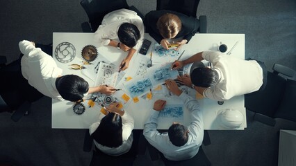 Top down aerial view of smart engineer team working together to design turbine engine. Professional...