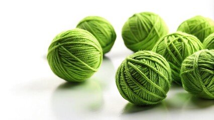 Fototapeta premium Green balls of yarn on a plain white background