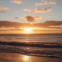 Obraz premium Stunning sunset view over a calm beach with golden skies and gentle waves. Ideal for travel, vacation, or relaxation themes. 