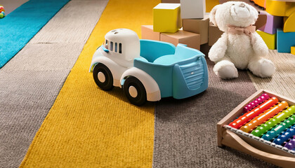 Fototapeta premium toy car on a carpet with multicolored cubes and toys