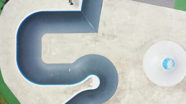 Ein Mann, der mit Inlineskates auf einer Halfpipe in einem Skatepark f&auml;hrt. 