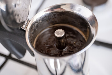 Brewing coffee with moka pot in close-up