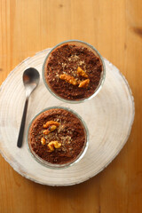 Two bowls of chia seed, chocolate and orange pudding. Healthy snack, wooden background. Top view.