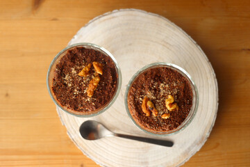 Two bowls of chia seed, chocolate and orange pudding. Healthy snack, wooden background. Top view.