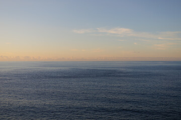 Sunset sky over the Atlantic Ocean, Tenerife. Minimalism. Misty morning in the sea. Calm view. Tranquil empty landscape with soft warm blue and gold pink sky. Natural dusk weather.