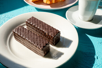 chocolate cake on a white plate and on blue background