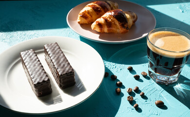 breakfast with coffee and croissant on blue background